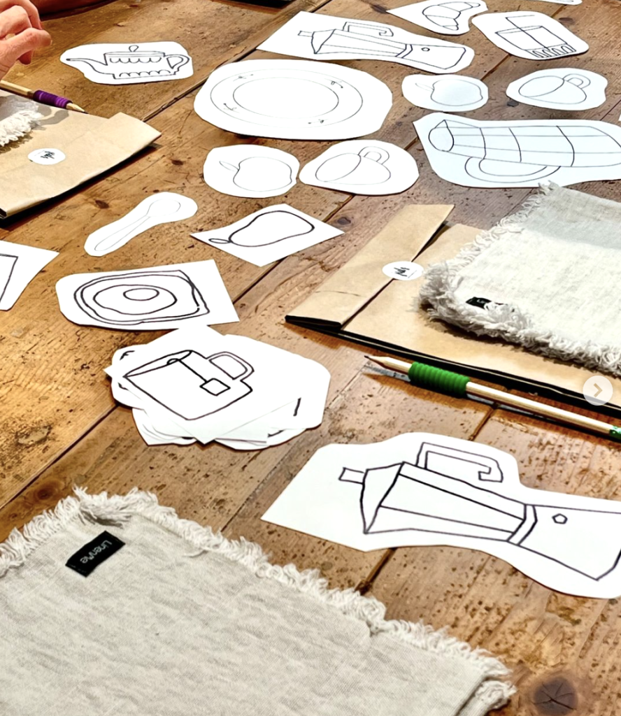 tavolo con disegni di tazze e accessori per la colazione per il workshop di ricamo